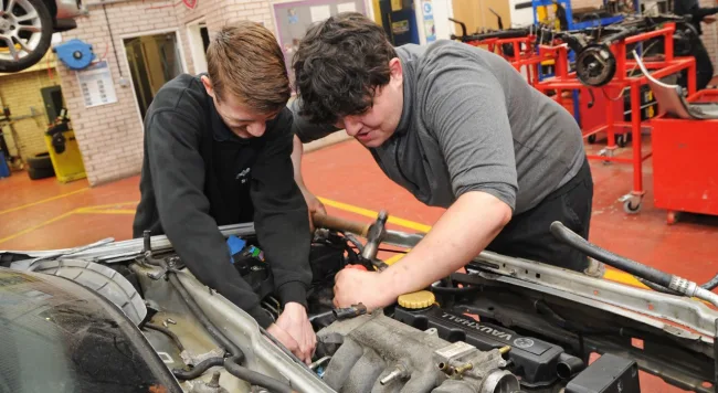 Students working on a car in motor vehicle workshop (Motor vehicle thumbnail)
