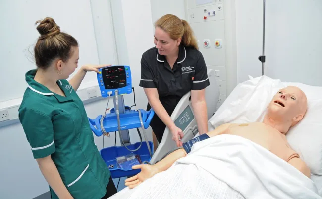 Tutor working with student in hospital ward